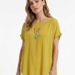 Femeie purtând un tricou galben închis și un lănțișor colorat