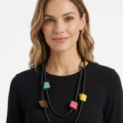 Femeie zâmbind cu un colier colorat din forme geometrice.
