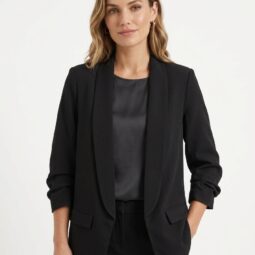 Femeie zâmbitoare îmbrăcată într-un sacou negru elegant