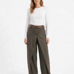 model feminin îmbrăcat cu bluză albă și pantaloni cu carouri